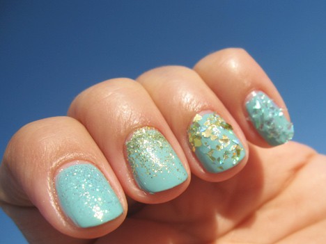 Een blauwe nagellak met gouden glitters nail art