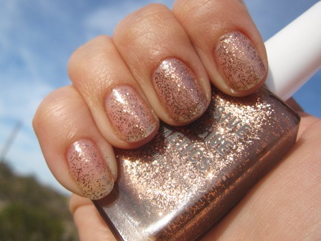 Een hand met een briljante koperen glitter in een heldere basis met een semi-ondoorzichtige / glitter afwerking nagellak met een nagellak van dezelfde kleur