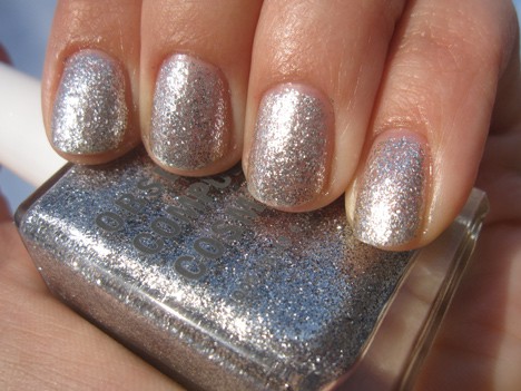 Een hand met een discobal zilveren glitter met een semi-ondoorzichtige/metallic afwerking nagellak met een nagellak van dezelfde kleur