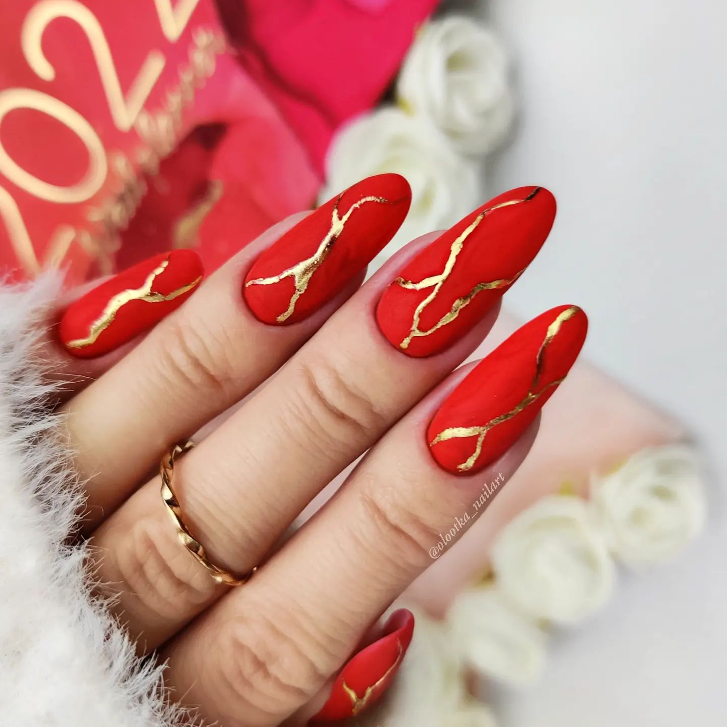 Lange matte rode nagels met goudfolie lijnen