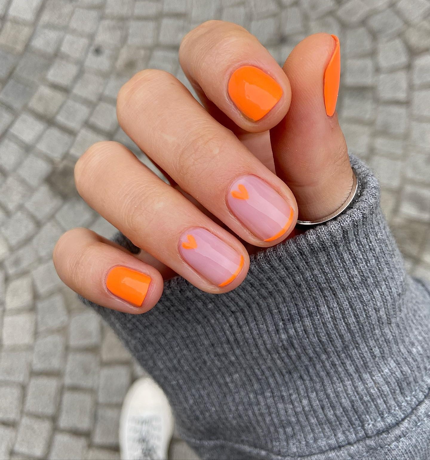 Korte oranje nagels met oranje punten en hartjes
