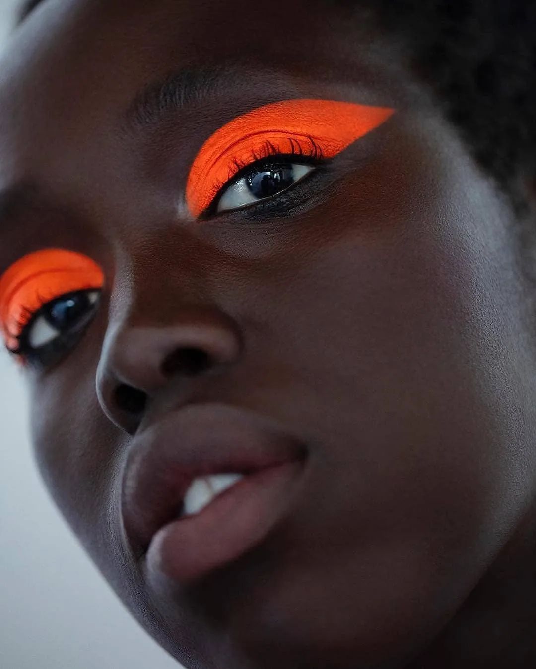 Oranje oogschaduw op donkerbruine huid