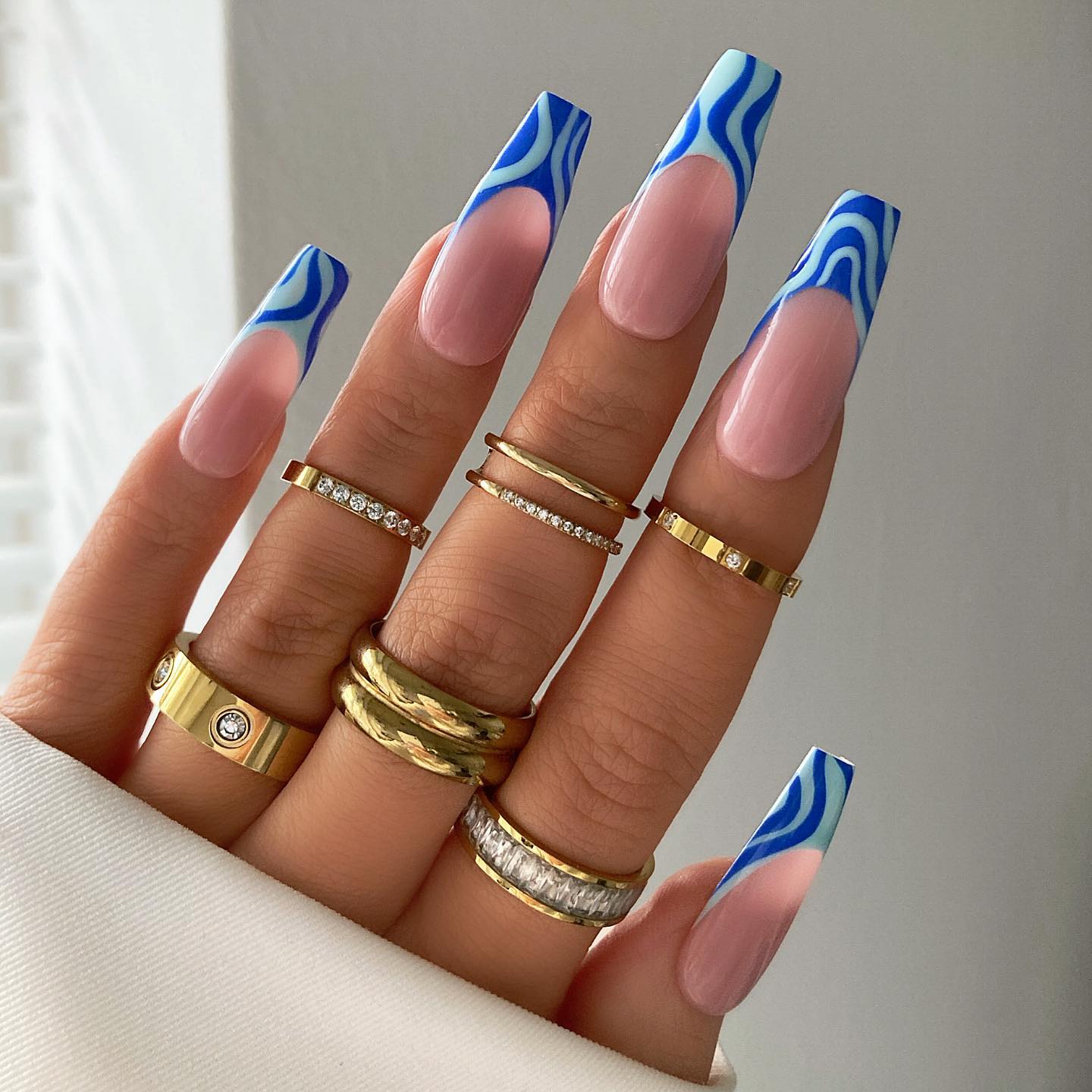 Franse nagels met blauwe geometrische wervelingen