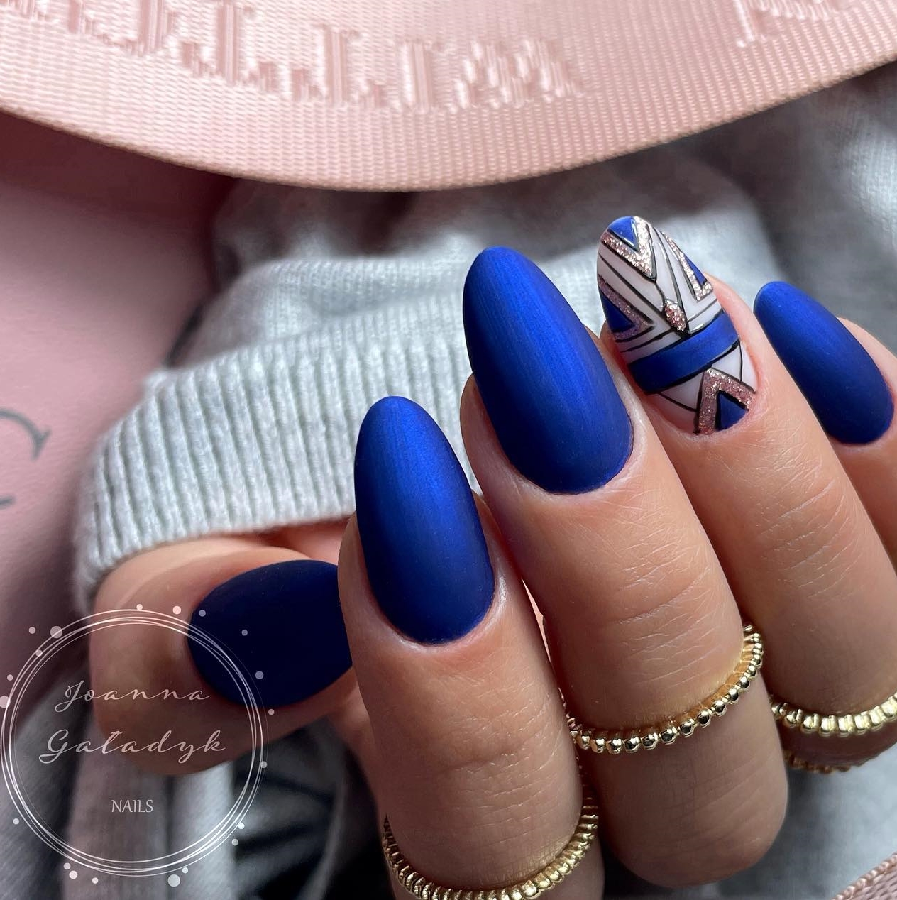 Ronde blauwe nagels met geometrisch ontwerp en gouden glitter