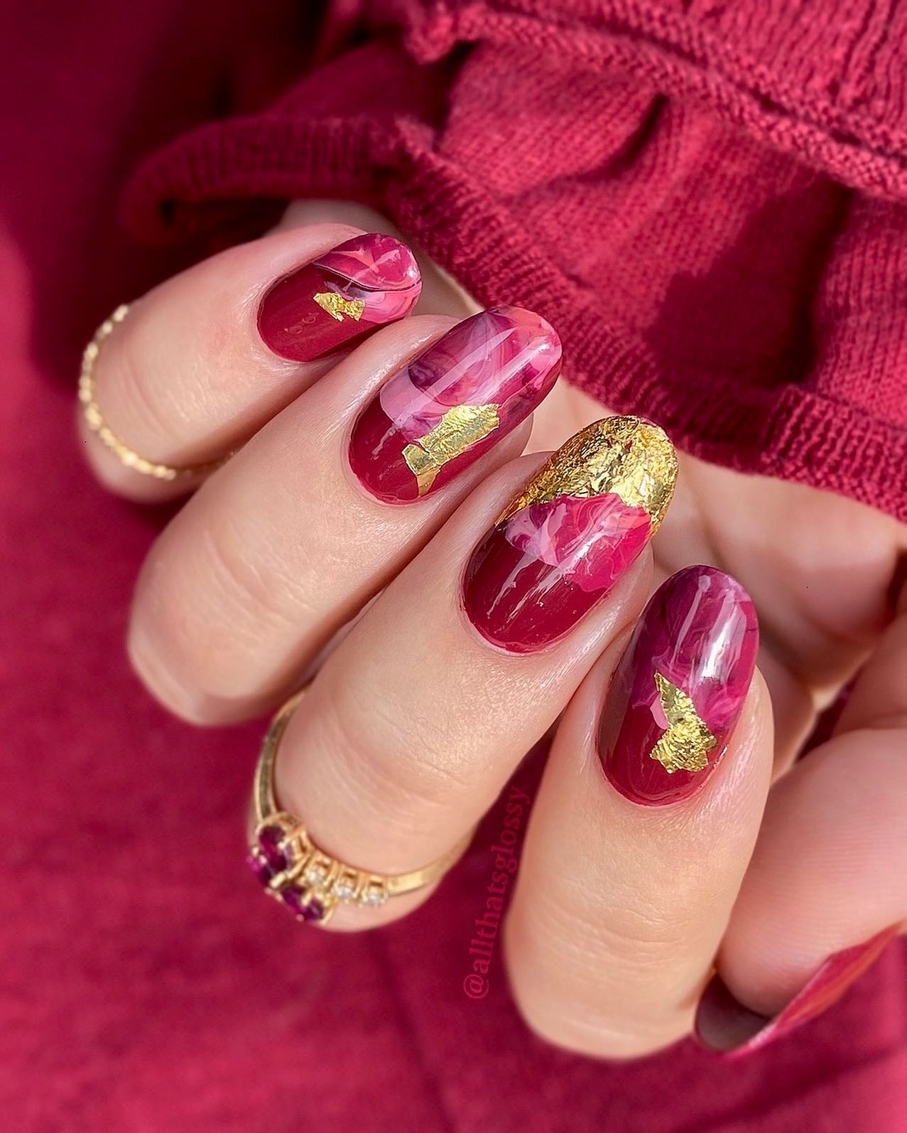 Ronde lichte bordeauxrode nagels met goudfolie en marmeren ontwerp
