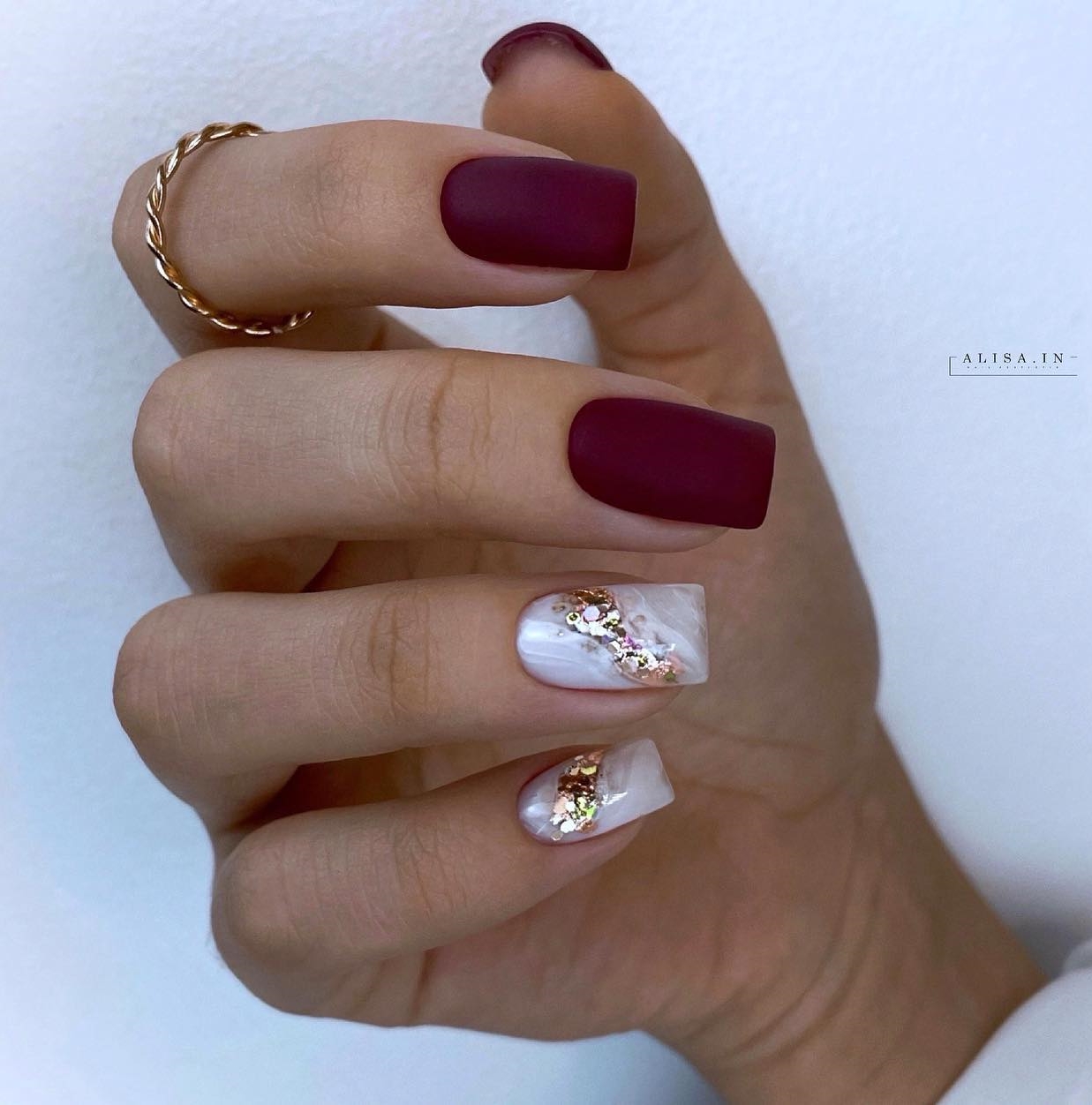 Vierkante matte bordeauxrode nagels met wit en goud ontwerp