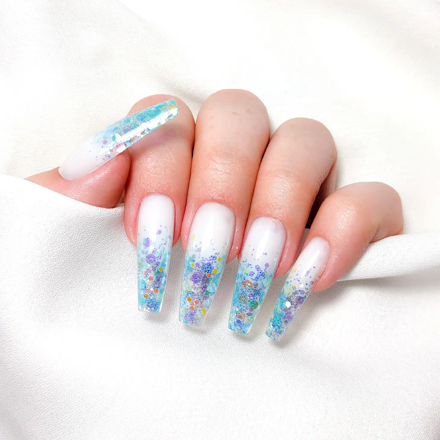 Witte nagels met blauwe glitter