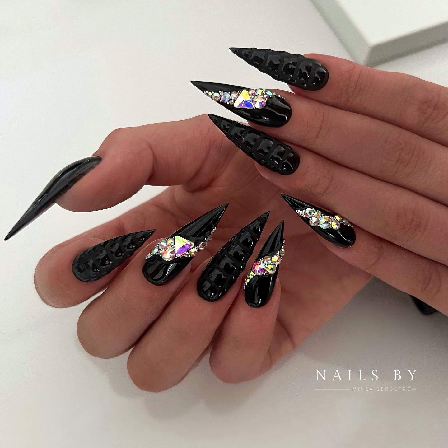 Lange getextureerde stiletto zwarte nagels met strass steentjes