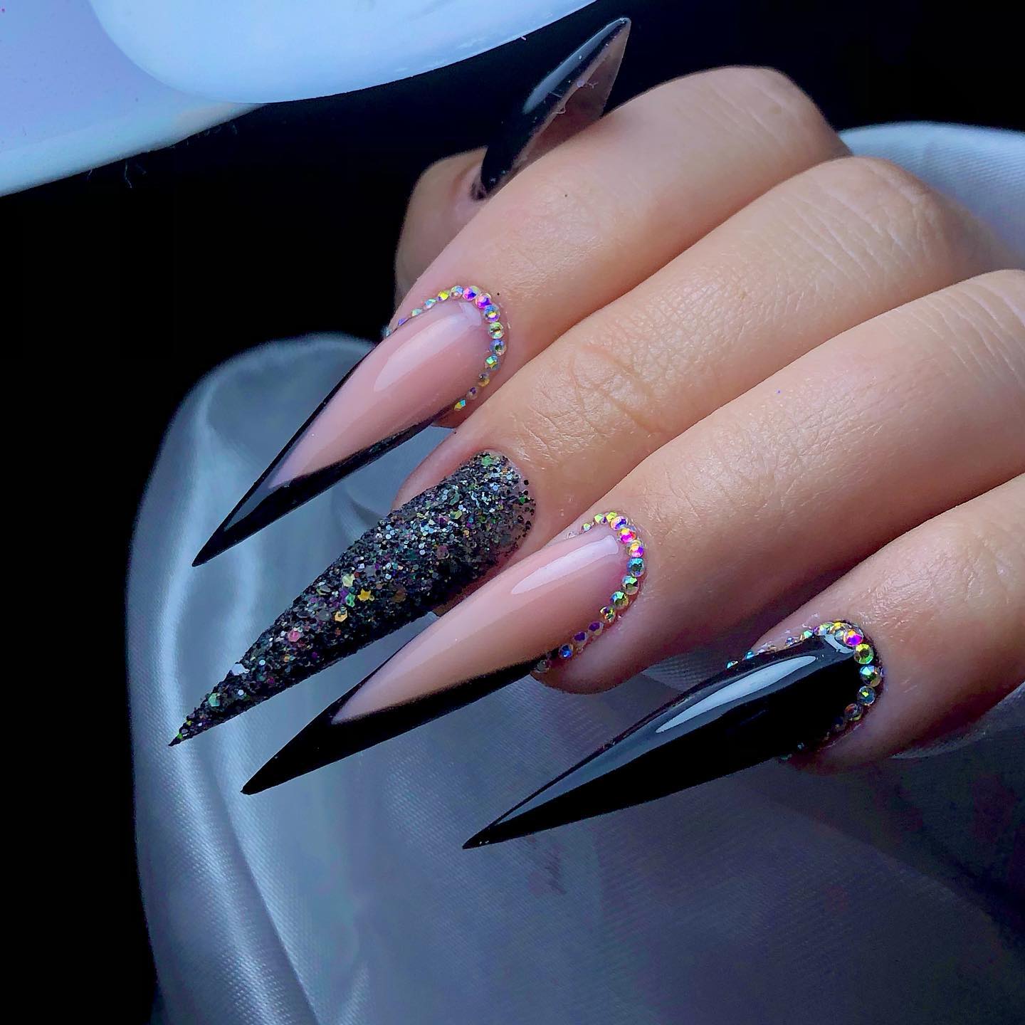 Lange acryl stiletto zwarte nagels met glitter en strass steentjes