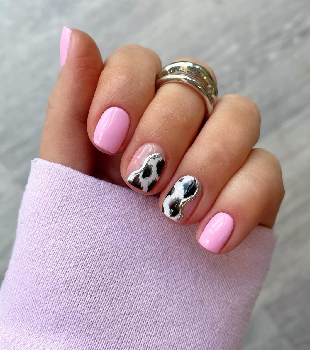 Korte roze nagels met zwart-witte koeienprint