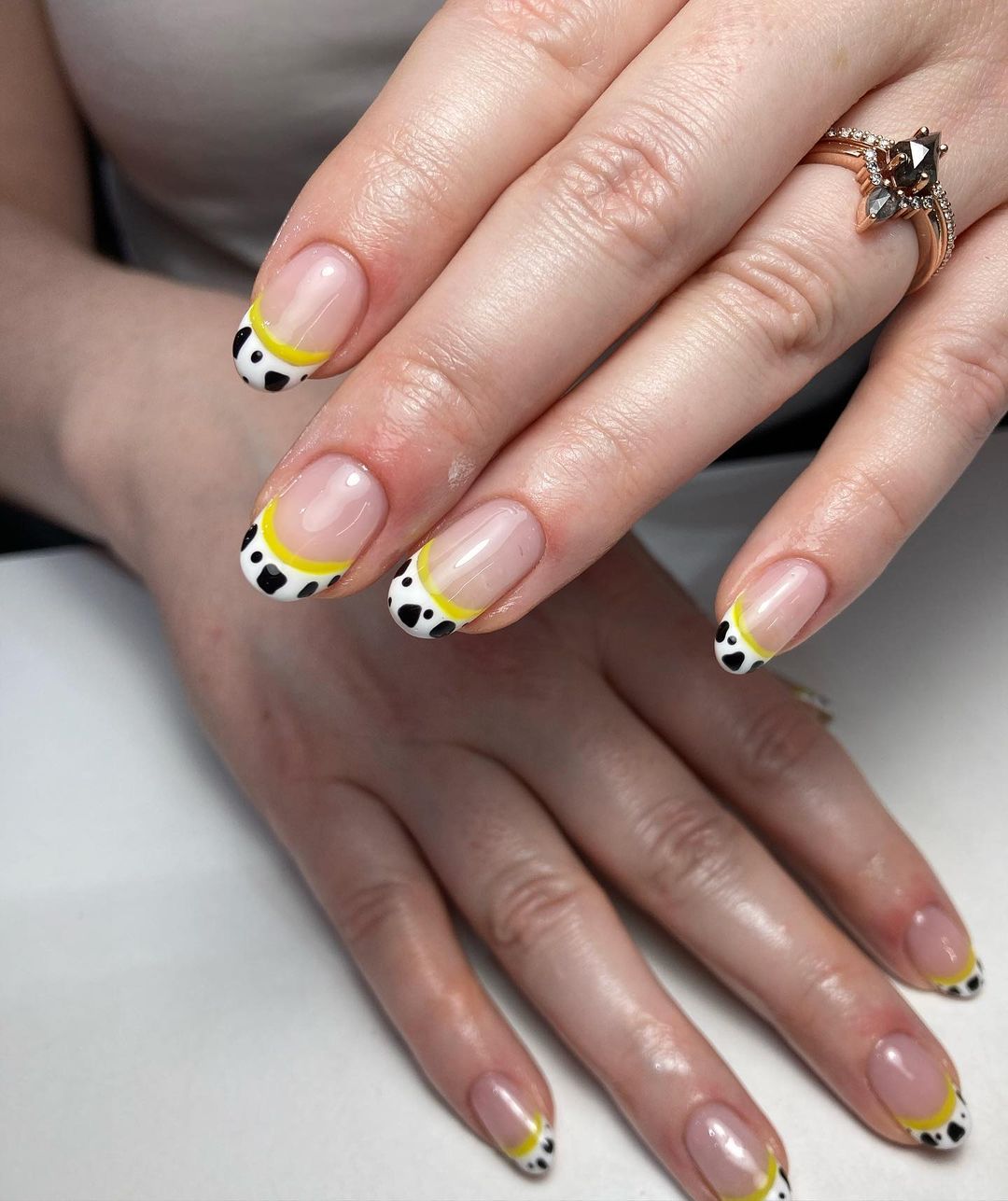 Korte ronde nagels met gele koeprint nageltips