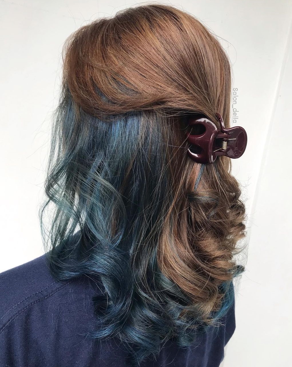 Donkerblauwe kiekeboe op golvend lichtbruin haar