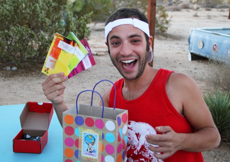 Een man die glimlacht terwijl hij een geschenktas vasthoudt
