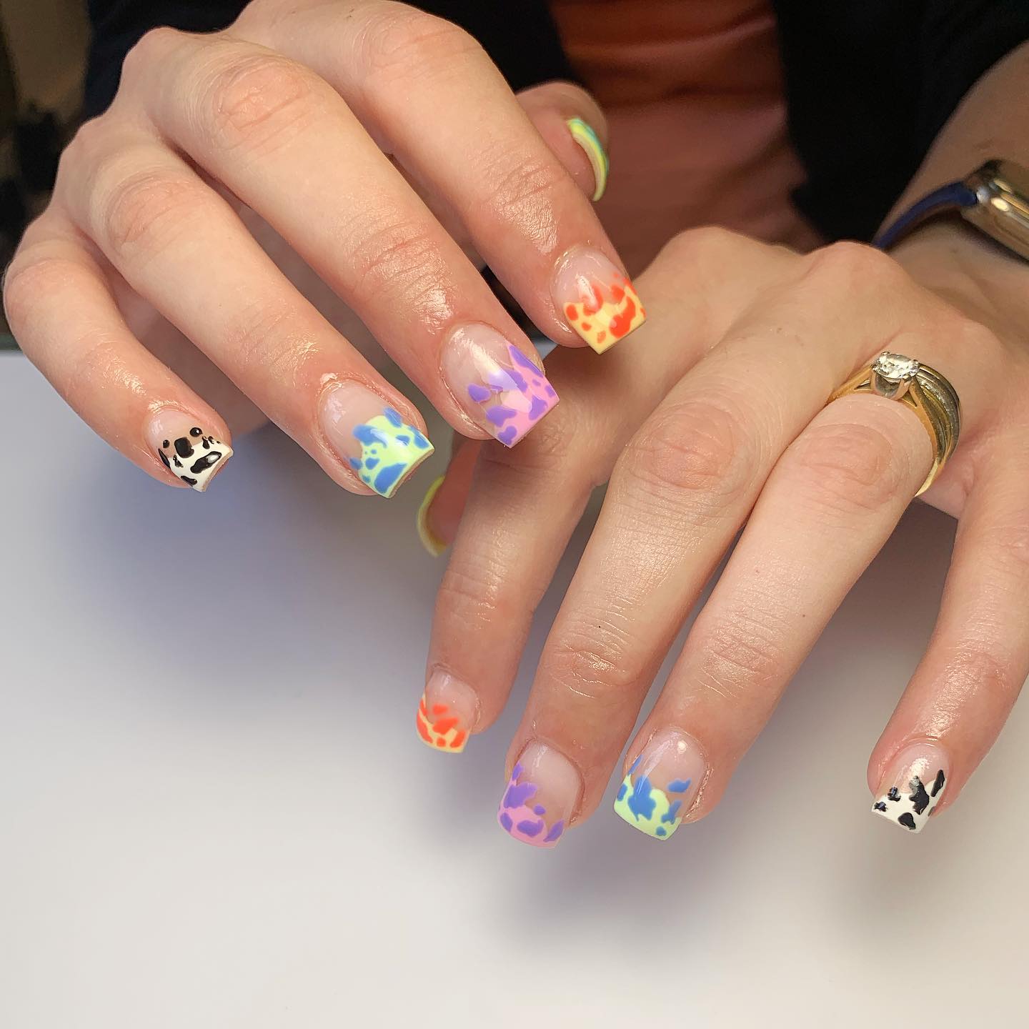 Korte vierkante nagels met regenboog koe print ontwerp