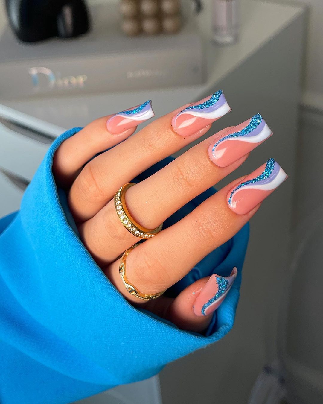 Vierkante nude nagels met blauw wervelend ontwerp