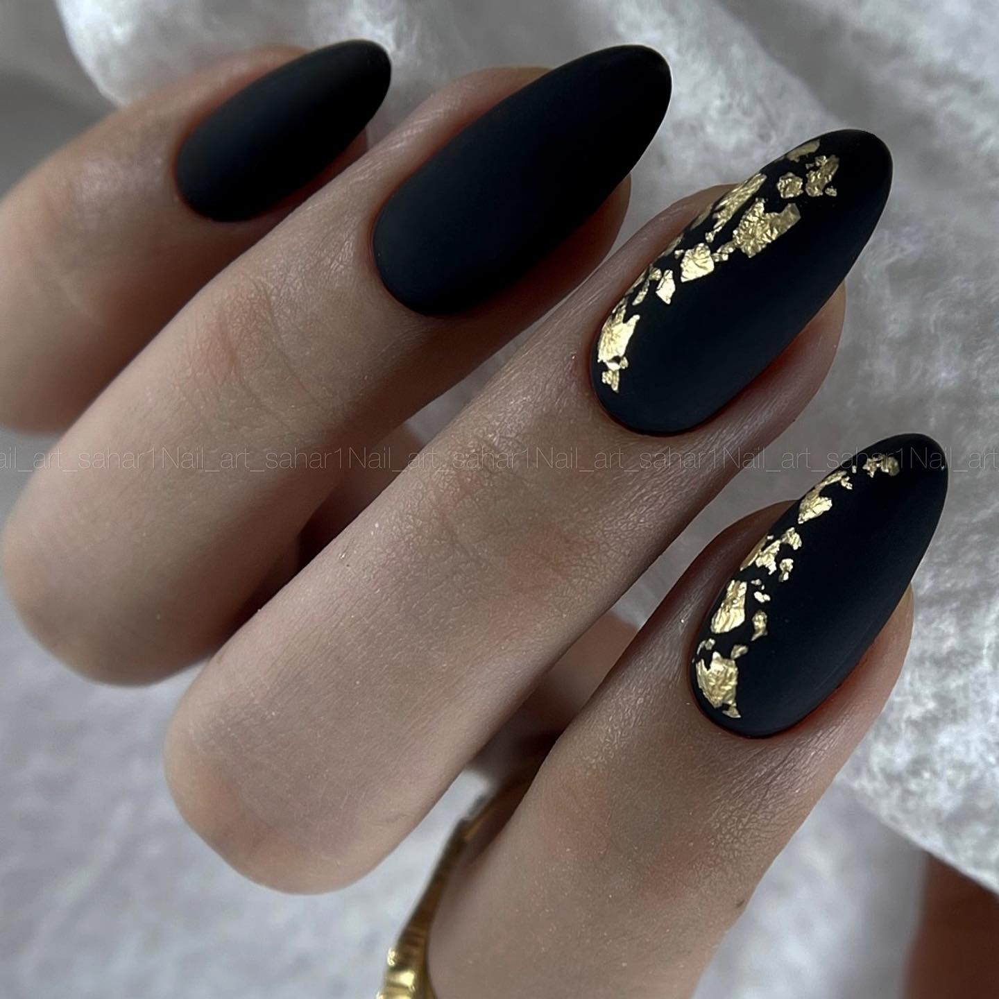 Zwarte matte nagels met goudfolie ontwerp