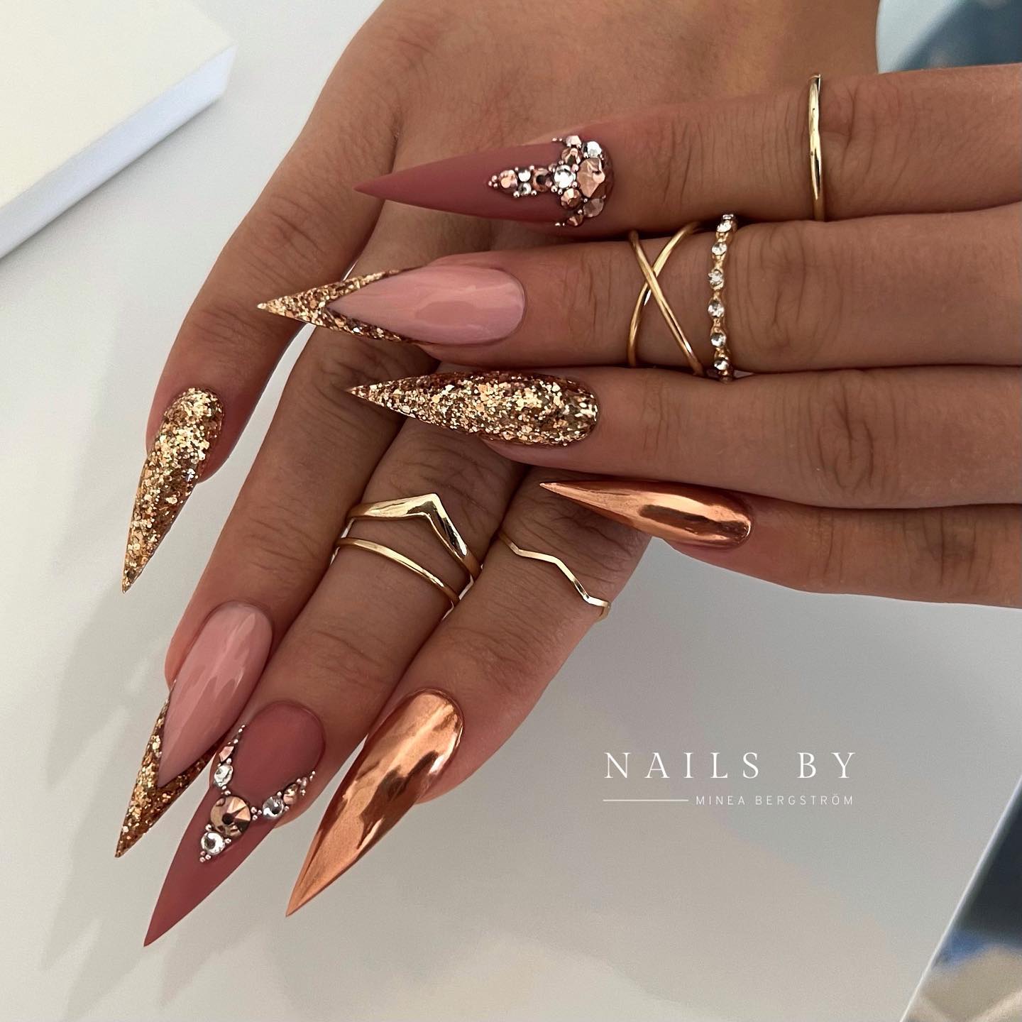 Puntige bruine nagels met gouden glitterontwerp