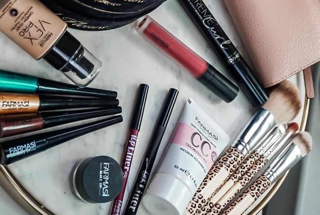 Een marmeren bureau met Farmasi cosmetica waaronder CC Cream, Cream Shadows, Matte Liquid Lipstick, Extreme Curl Mascara en meer!