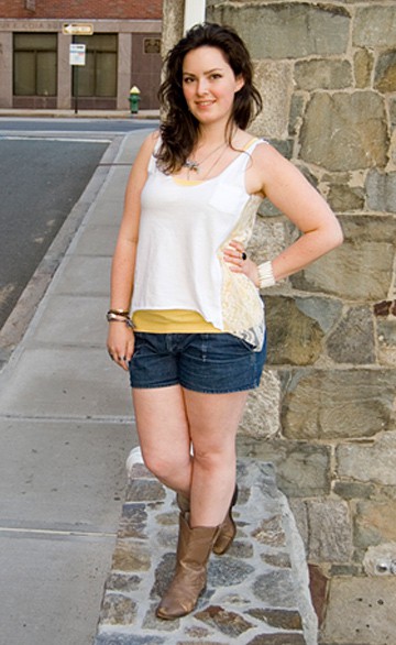 vrouw die witte kanten tanktop met denim shorts draagt