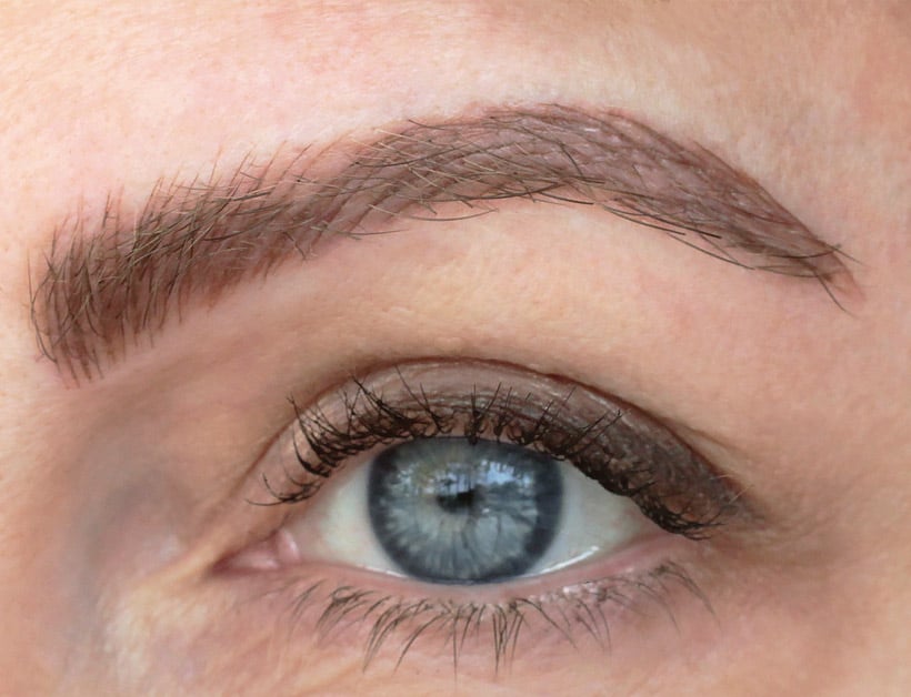 close-up afbeelding van het oog van een vrouw met microbladed wenkbrauwen