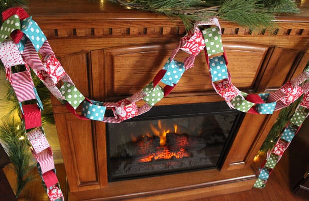 DIY stof kerstslinger opgehangen aan een houten mantel