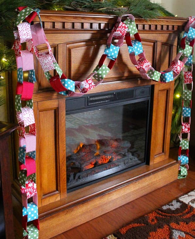 DIY stof kerstslinger opgehangen aan een houten mantel