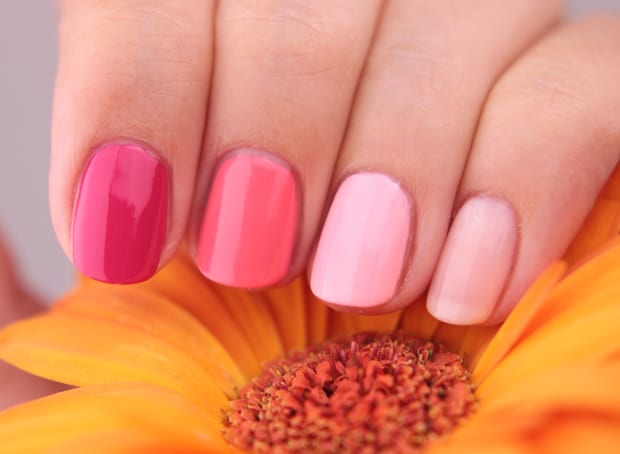 roze tinten essie gel nagellak op de vingernagels van de vrouw met een gele bloem