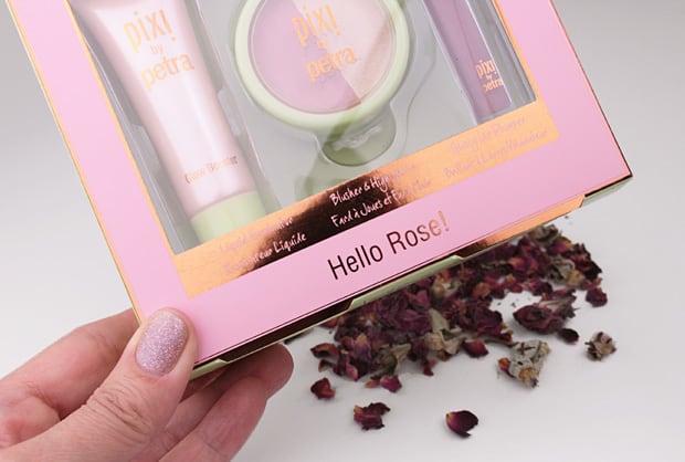   Pixi Hallo Roos! Geplaatst in een gouden en paarse verpakking met paarse en witte rozenblaadjes op een witte achtergrond