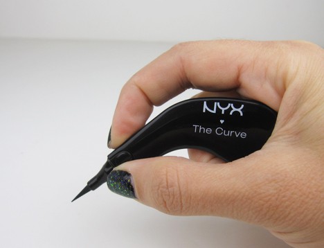 Een hand die een NYX Curve Eyeliner op een witte achtergrond vasthoudt