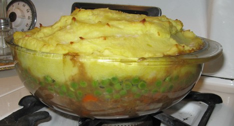 Vegetarische herderstaart in een glazen pan op het fornuis