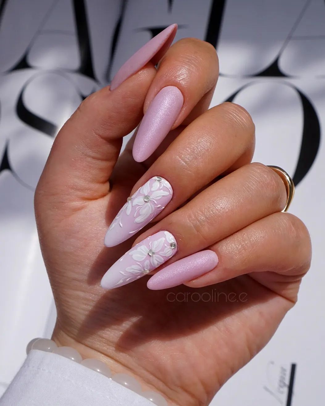 Lange amandelroze nagels met wit bloemendessin