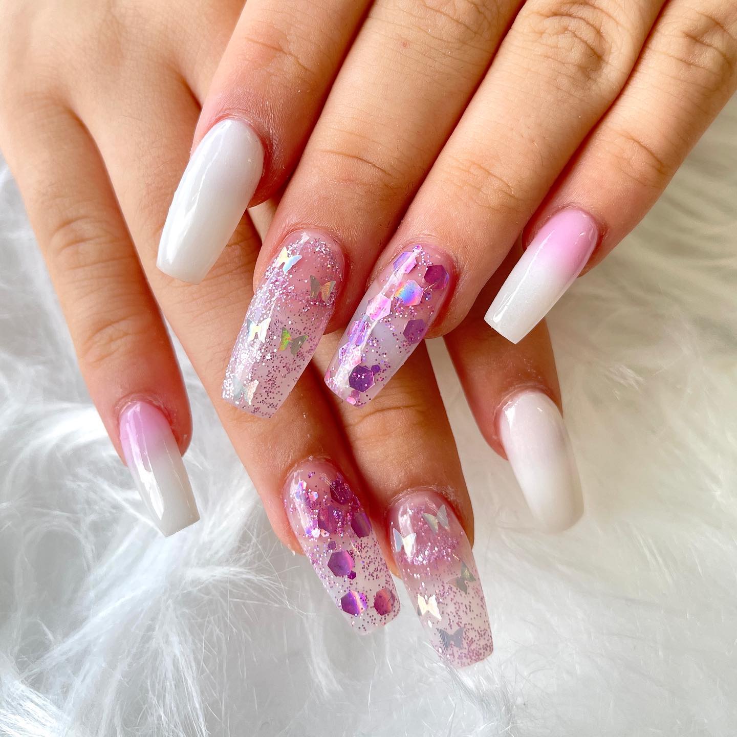 Roze en witte nagels met zilveren vlinders