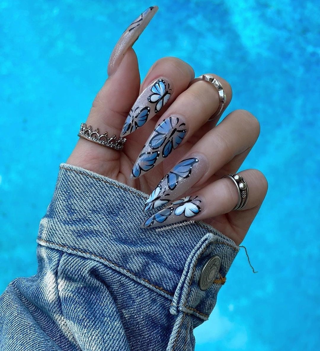 Lange heldere nagels met blauw vlinderontwerp
