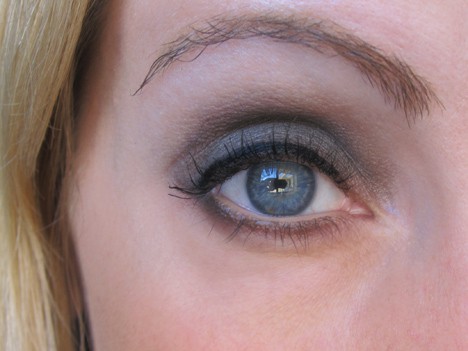 Een gesloten foto van een eenogige blonde vrouw met oogschaduw en mascara