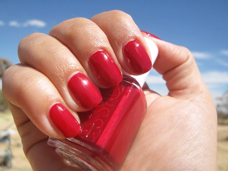 Een hand met een klassieke rode nagellak met een essie nagellak