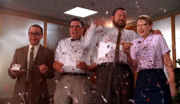 Een vrouw en drie heren vieren een feest met confetti terwijl ze met bloed worden bespoten