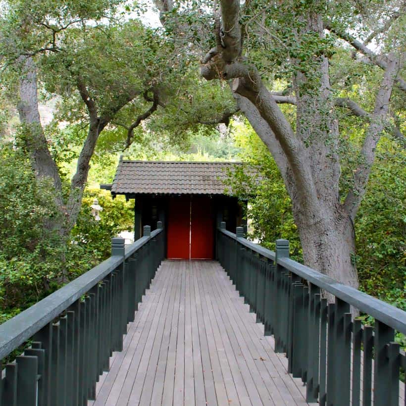 brug naar de hoofdlobby met rode deur en bomen op de achtergrond
