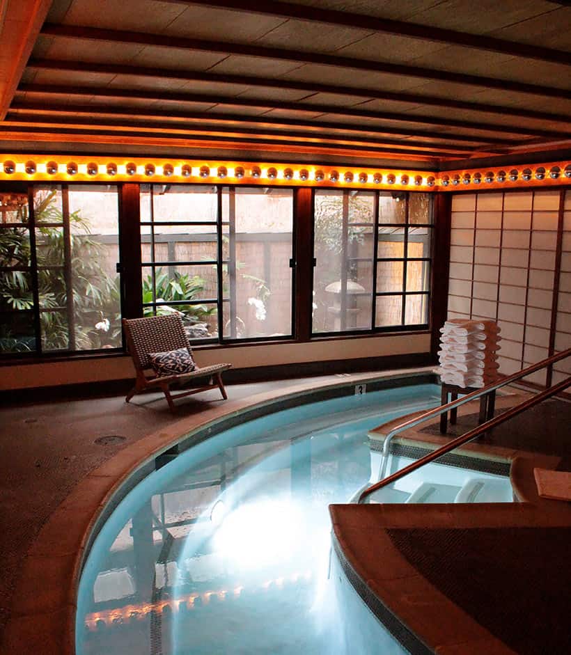 Een spa-behandelplaats met char en een mini-zwembad met handdoeken op de achtergrond