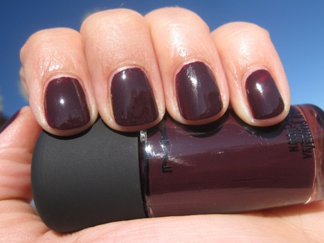 Een hand met een paarse crème nagellak met een nagellak blauwbloed tint