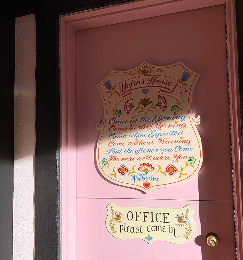 Hofsas huis roze deur met tekstdecoratie