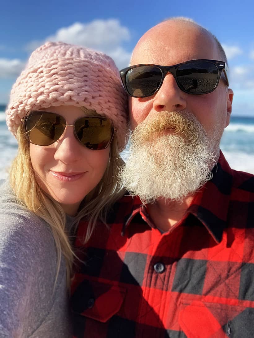 Een man en een vrouw in schaduwen die een foto maken op het strand