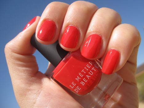 Een hand met een rode nagellak met een Red Hot Tango Nail Lacquer