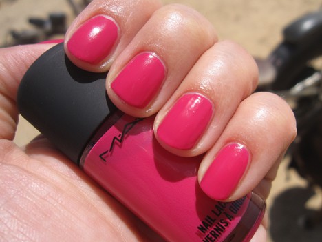 Een hand met een hete roze nagellak met een macnagellak