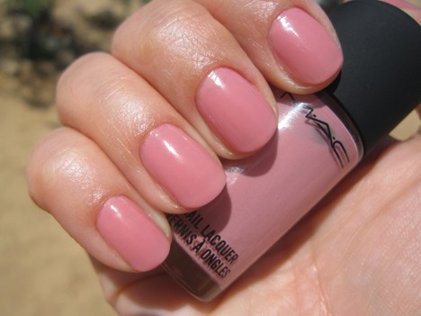 Een hand met een koele roze nagellak met een MAC nagellak